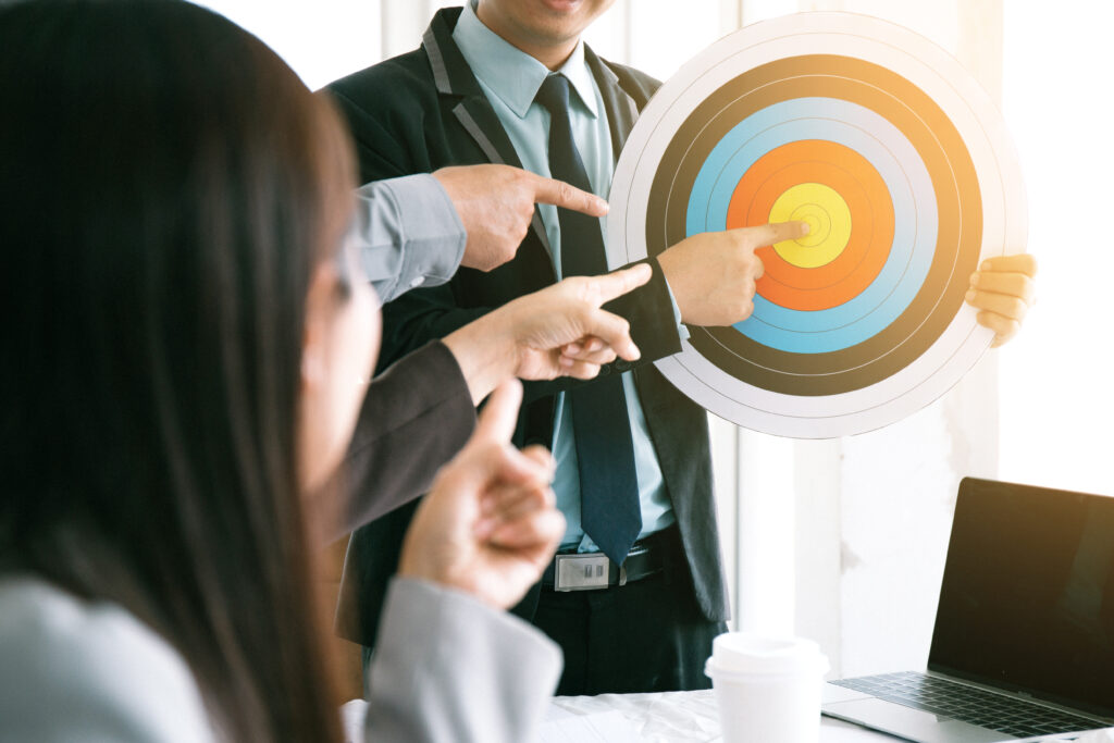 A sales and marketing team pointing at a target